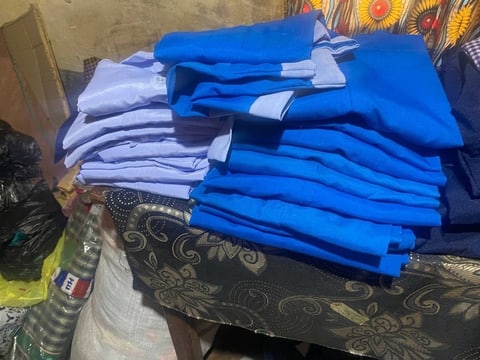 Piles of new bright blue and light blue school shirts folded on a table