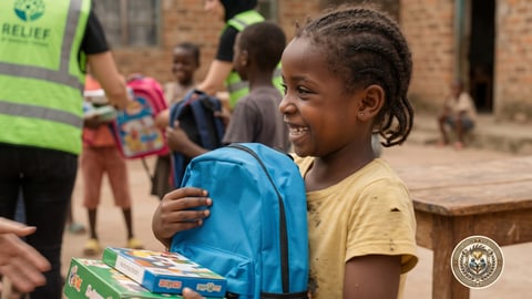 A smiling girl receiving a new blue school bag
