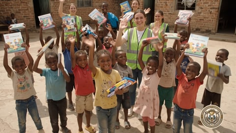 Children cheering and holding their new books high