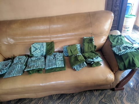 New green gingham school uniforms laid out on a sofa
